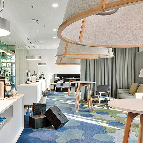 Moderne Hotellobby mit runden Hängelampen und buntem Teppich