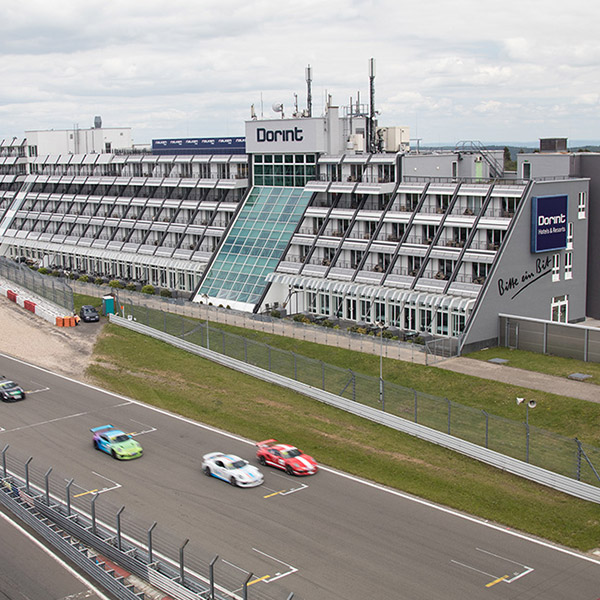 Dorint Hotel am Nürburgring mit Rennstrecke und Rennwagen im Vordergrund