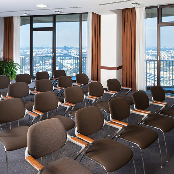 Seminarraum in Reihenbestuhlung mit Panoramafenstern und Stadtblick