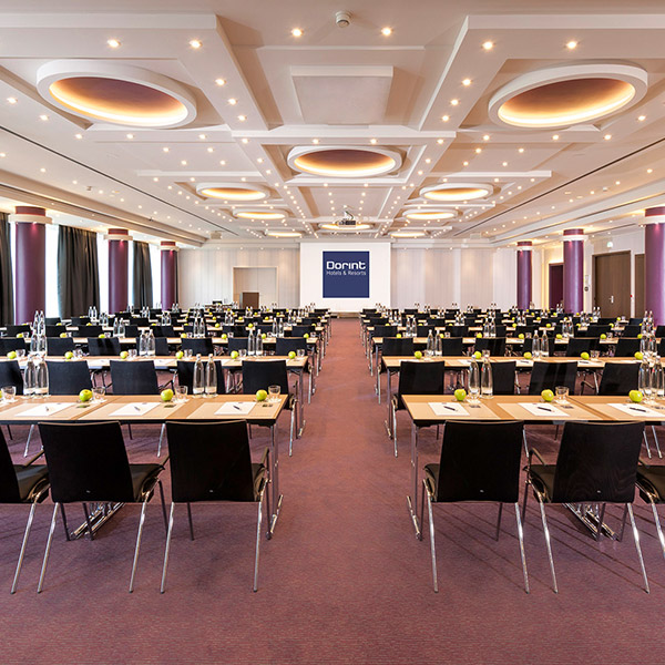Konferenzraum mit parlamentarischer Bestuhlung, mit Tagungssetup, Block, Glas und Apfel